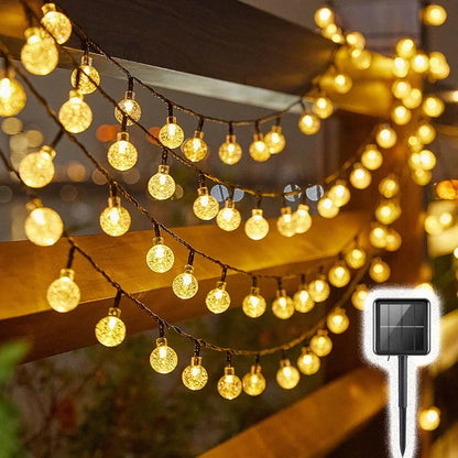 Solar-powered bubble crystal ball string lights hung on a balcony, adding a warm glow to the holiday decor.