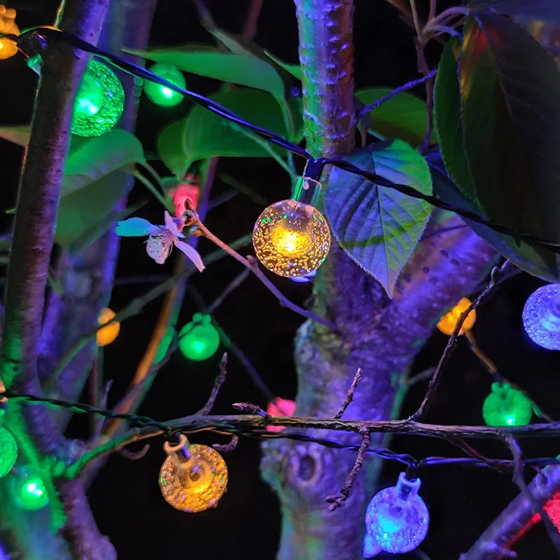 Solar-powered bubble crystal ball string lights hung on a balcony, adding a warm glow to the holiday decor.