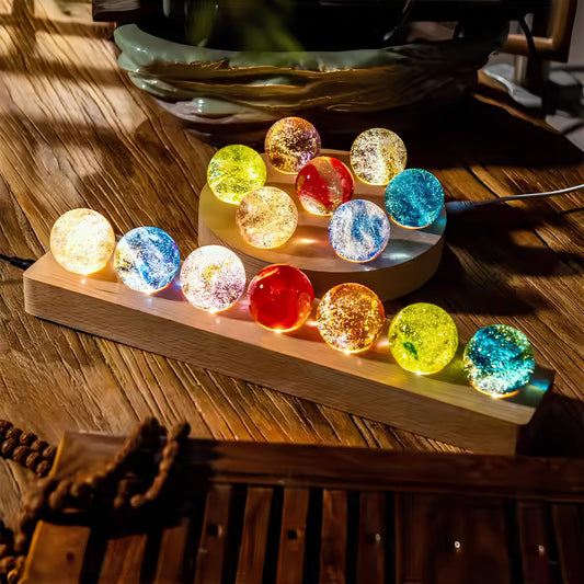 Seven galaxy-themed glass orbs on a wooden base, USB-powered ambient lighting for home decor with vibrant colors and cosmic designs.