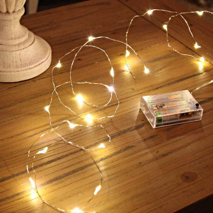 Battery-operated Christmas lights with LED bulbs on flexible copper wire, perfect for indoor and outdoor holiday decor, weddings, and parties.