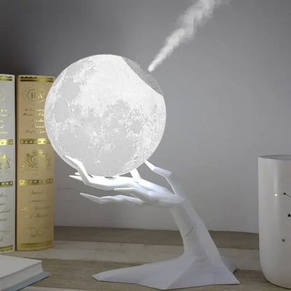 Moon-shaped ultrasonic air humidifier and LED lamp in a hand-shaped stand, ideal for creating a relaxing and fragrant atmosphere.