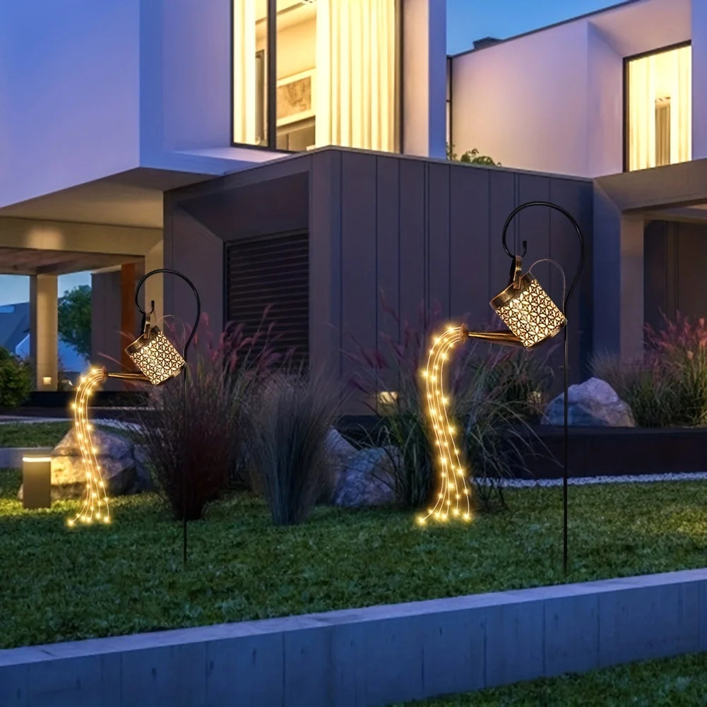 Solar-powered watering can lights with star-shaped LEDs for outdoor Christmas or garden decor.