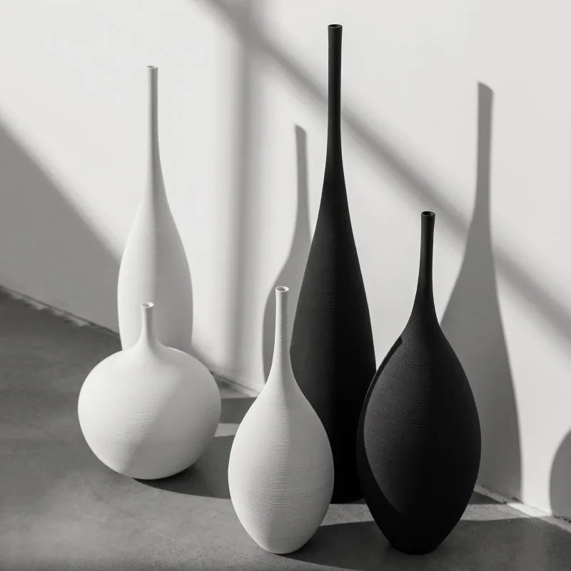 Minimalist black and white ceramic vases in sleek, modern shapes, set against a neutral background for a contemporary aesthetic.