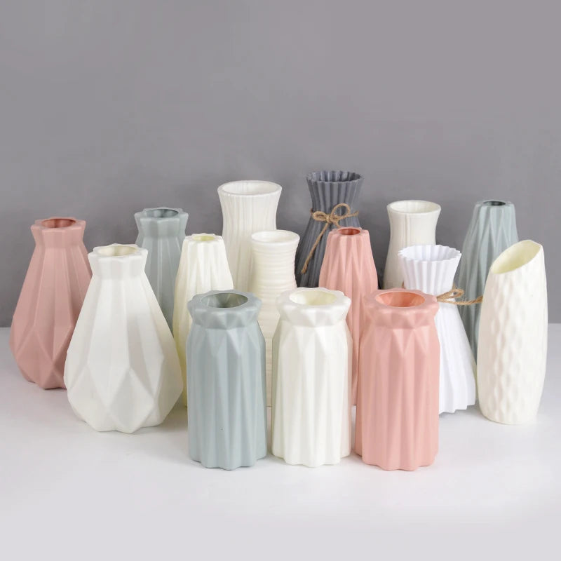 Set of pastel-colored Nordic ceramic plastic vases in geometric shapes displayed elegantly on a white surface, perfect for floral arrangements or home décor.