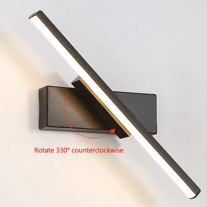 Modern LED wall light with rotatable design installed beside a bed