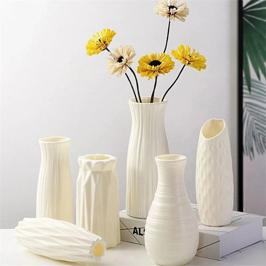 Collection of modern plastic flower vases in elegant Nordic designs, displayed with bright yellow flower arrangements, ideal for home and table décor.