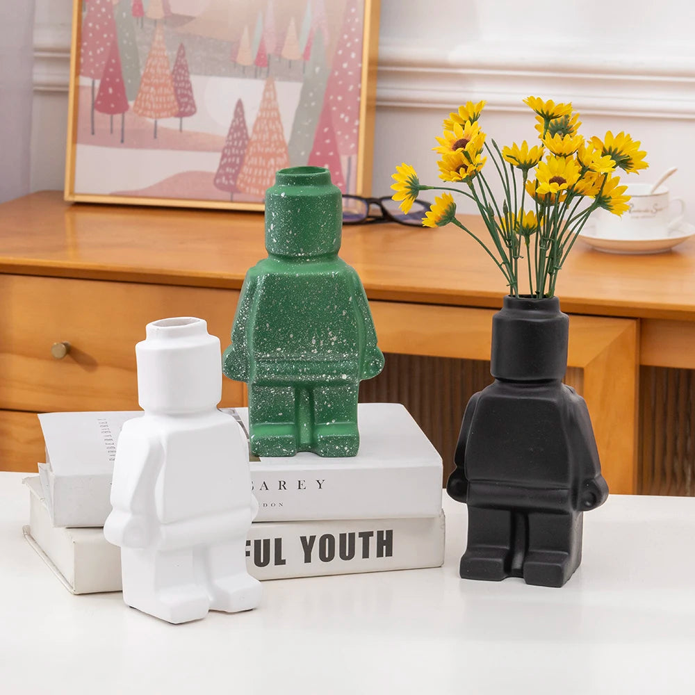 Green ceramic robot vase with speckled finish, ideal for modern and playful home decor.