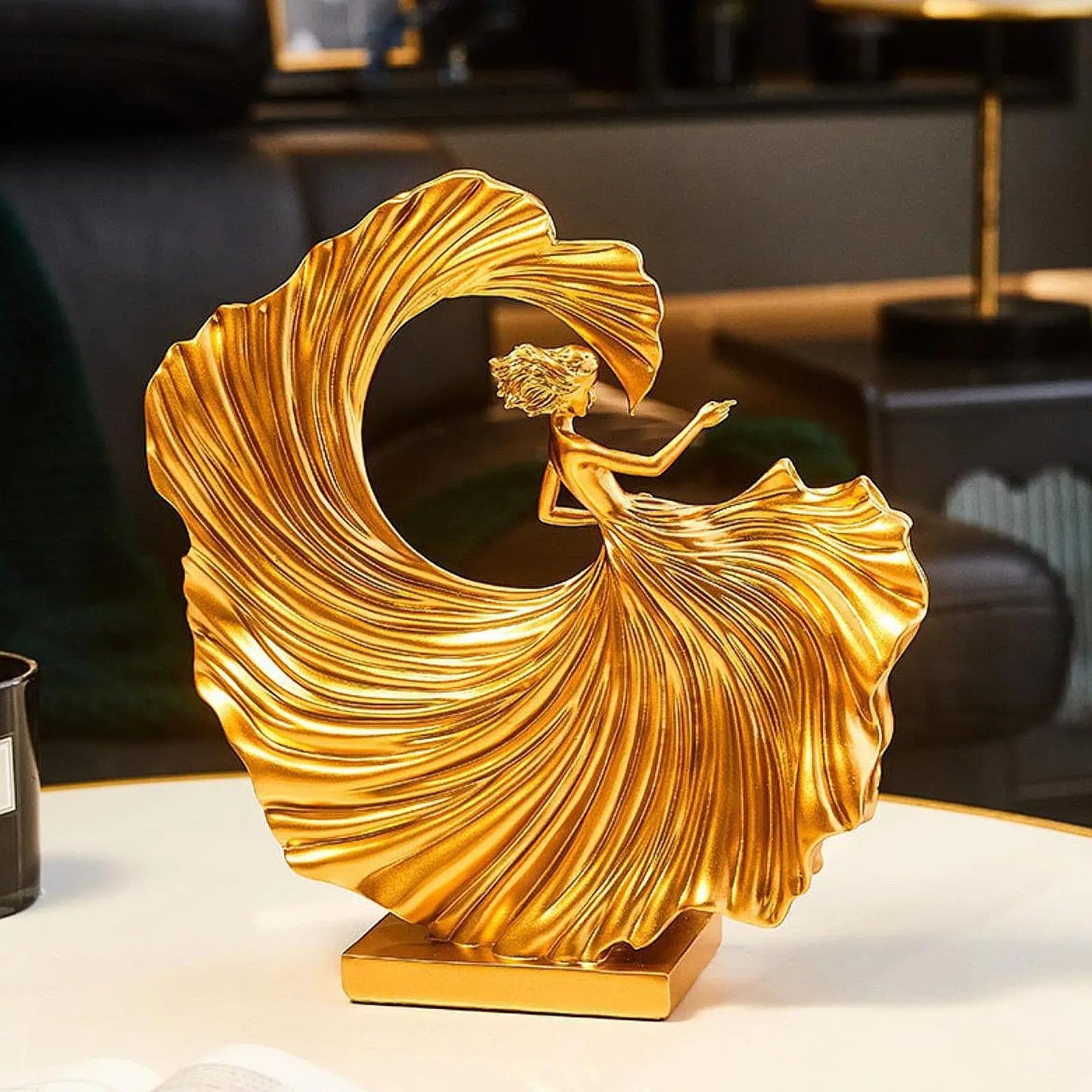 Golden resin statuette of a dancing girl with a flowing dress, modern art decor for homes and offices.