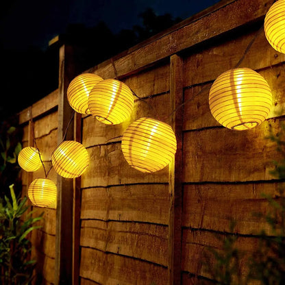 Solar-powered lantern fairy string lights illuminating a garden for Christmas or outdoor decor.