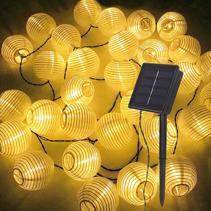 Solar-powered lantern fairy string lights illuminating a garden for Christmas or outdoor decor.