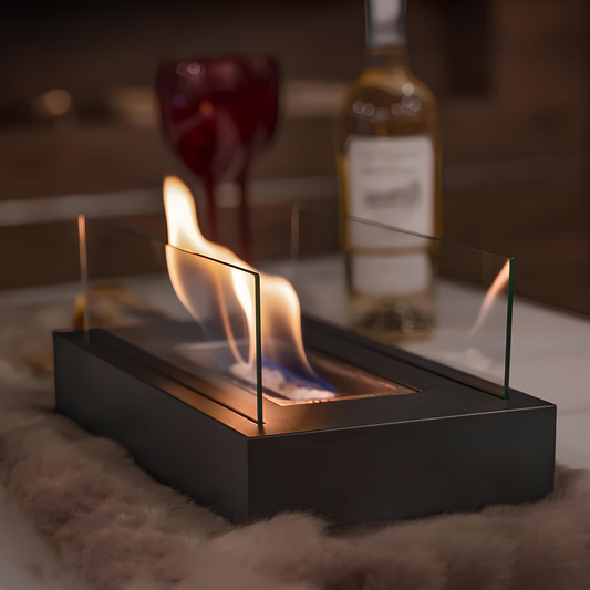 Elegant rectangular tabletop fireplace with clear glass walls and an open flame, providing cozy ambient lighting in an indoor setting.