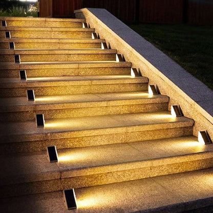 Solar-powered LED lights installed along outdoor steps, providing warm white illumination for safety and ambiance.